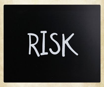 The word "Risk" handwritten with white chalk on a blackboard