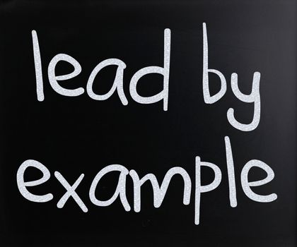 "Lead by example" handwritten with white chalk on a blackboard