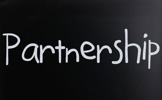 The word "Partnership" handwritten with white chalk on a blackboard