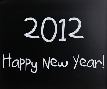 "Happy New Year" handwritten with white chalk on a blackboard