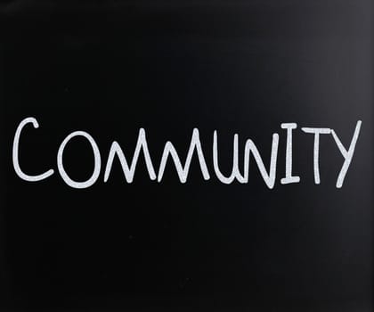 "Community" handwritten with white chalk on a blackboard