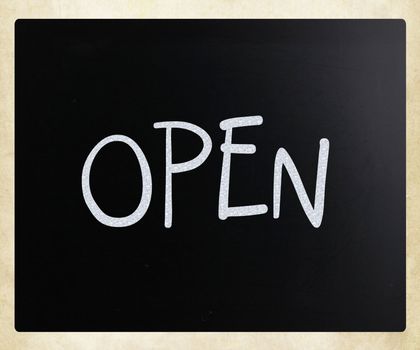 The word "Open" handwritten with white chalk on a blackboard