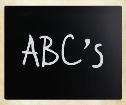 "ABC's" handwritten with white chalk on a blackboard