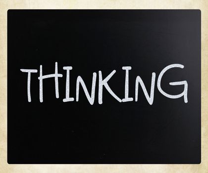 "Thinking" handwritten with white chalk on a blackboard