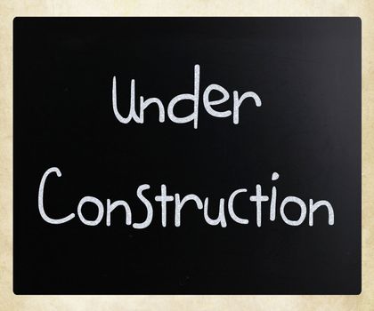 "Under construction" handwritten with white chalk on a blackboard