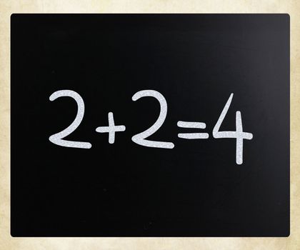 "2+2=4" handwritten with white chalk on a blackboard