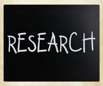 "Research" handwritten with white chalk on a blackboard