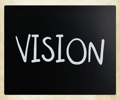 "Vision" handwritten with white chalk on a blackboard