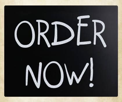 "Order now" handwritten with white chalk on a blackboard