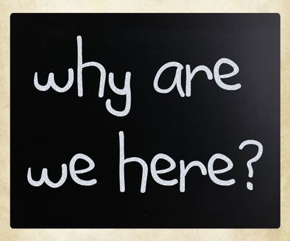 "why are we here" handwritten with white chalk on a blackboard