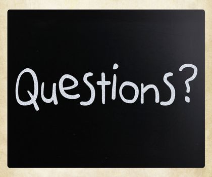"Questions?" handwritten with white chalk on a blackboard