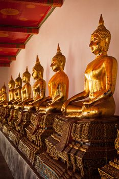 Row of sitting Buddha statues in Buddhist temple Wat Pho, Bangkok, Thailand