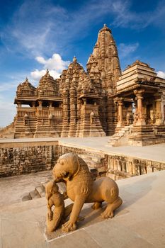 King and lion fight statue and Kandariya Mahadev temple.  Khajuraho, India