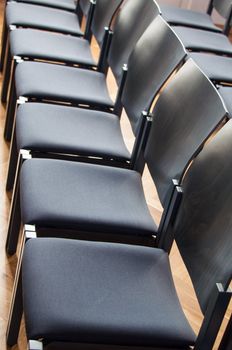 Rows of dark wooden and plastic chairs