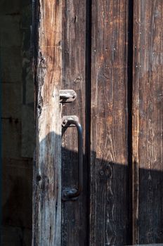 rustic wooden barn door with rusty metal handles