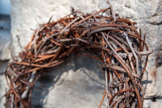 Willow dry branches wreath isolated on stone wall