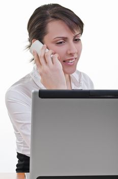 A portrait of office assistant looking at laptop screen and answering phone call, focus on eyes, vertical shot