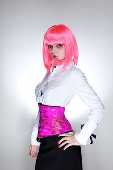 Young woman dressed in white shirt and oriental corset, studio shot over white background 