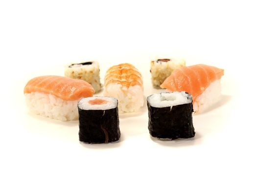 fresh Japanese sushi with salmon, shrimp, carrots and cucumber on a light background