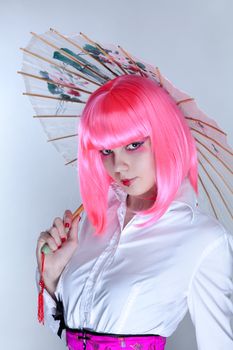 Young woman with oriental make-up holding Japanese umbrella  