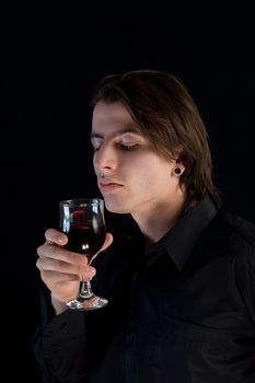 Handsome vampire with glass of wine or blood, Halloween theme 