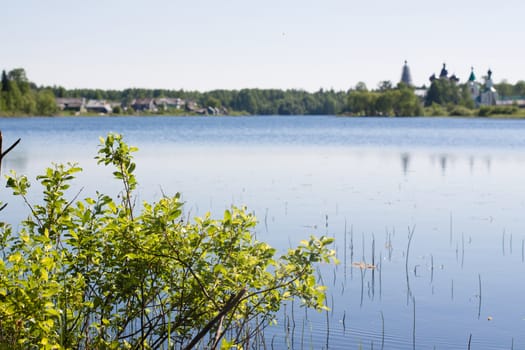 A lanscape with lake, an old orthodox white convent and small village
