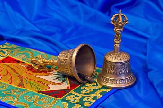two Tibetan ritual bells on a blue background