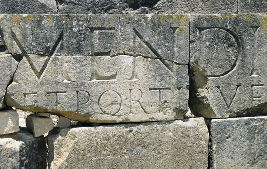 Fragment of Roman ruins with Latin letters from the city of Dougga in Tunisia