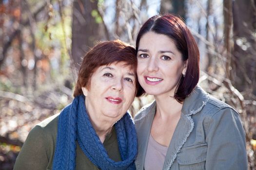 Women - adult daughter and mother - smiling and looking at the camera.