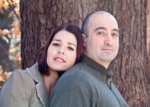 Portrait of smiling husband and wife couple hugging and looking at the camera.