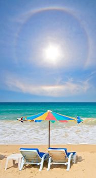 Couple chair and multi-color umbrella on the beach with perfectly sky