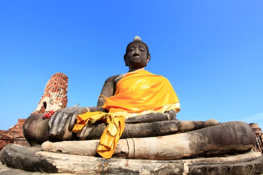 black buddha statue over blue sky