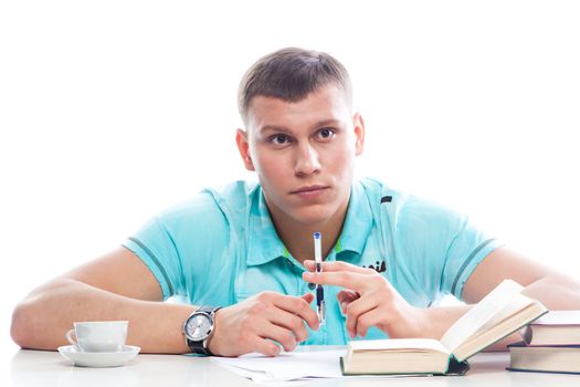 Portrait of a young attractive guy who is preparing for the exams at a university or college