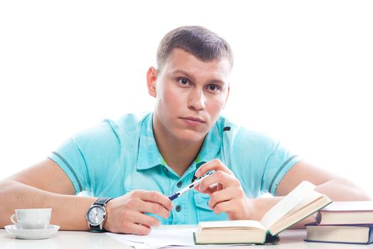Portrait of a young attractive guy who is preparing for the exams at a university or college