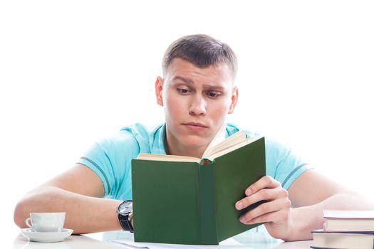 Portrait of a young attractive guy who is preparing for the exams at a university or college
