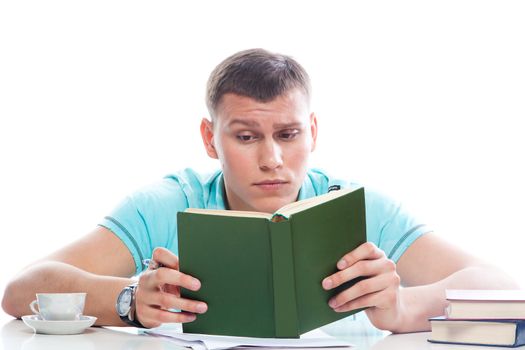 Portrait of a young attractive guy who is preparing for the exams at a university or college
