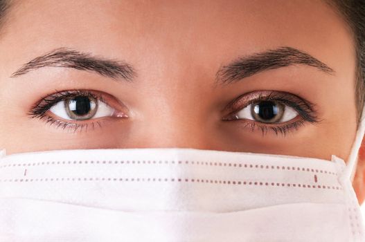 Woman in white medical mask. Selective focus on eyes.