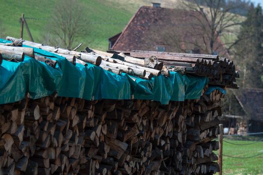 Image of a pile of firewood and old farmhouse