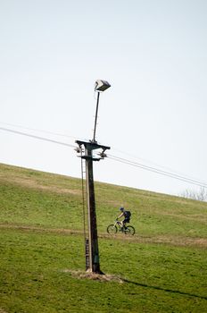 skilift in the mountains on a green lawn during the summer with mountain biker