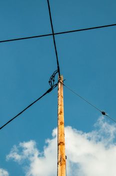 Telephone pole and wires in front of great blue sky