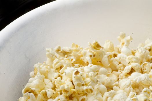 bowl of popcorn with some empty black space in upper left corner