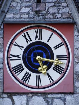 An old clock with gold hands and roman numerals