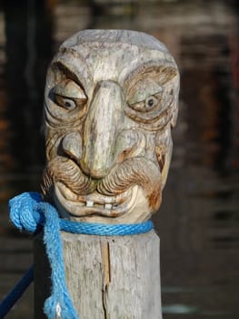 A carved face sculpture on pier