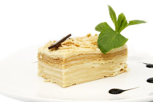 piece of layer cake decorated with a mint on a white plate