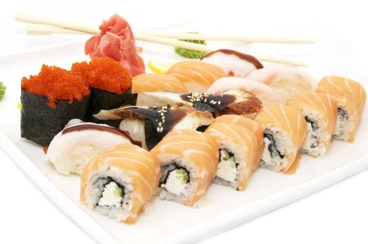 plate of sushi with fish and chopsticks on white background