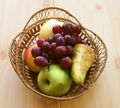 Basket with fresh fruit on wooden table