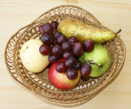 Fruits in braided basket on table