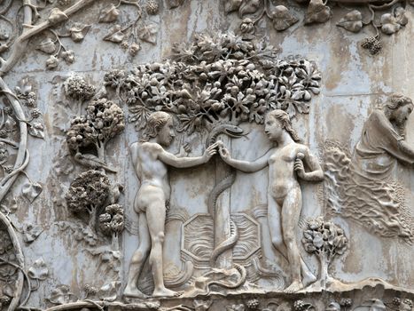 orvieto - Duomo facade. The first pillar: scenes from Genesis.Eve offers the forbidden fruit to Adam.