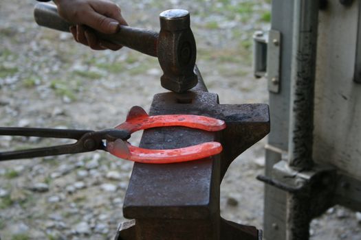 Blacksmith at work while changing a horseshoe