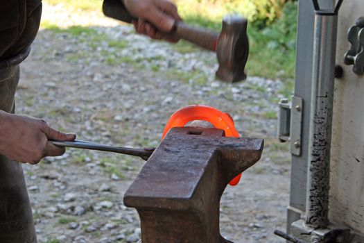 Blacksmith at work while changing a horseshoe